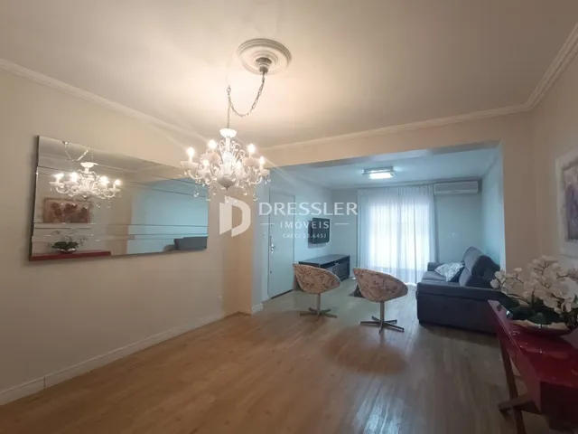 Sala de estar com piso de madeira e espelho refletindo o ambiente.