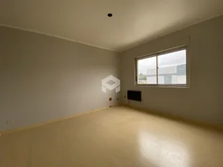 Sala de estar com piso de madeira clara e janela.