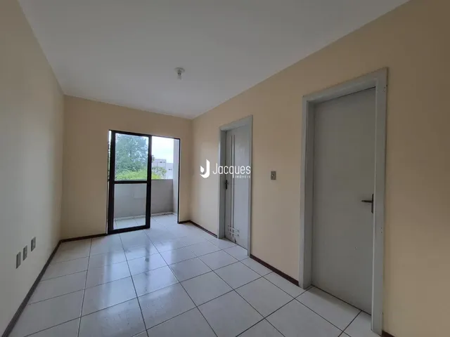 Hall de entrada com piso de cerâmica e paredes claras.