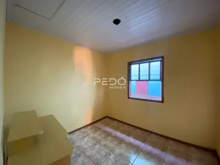 Quarto com paredes amarelas e piso de cerâmica.