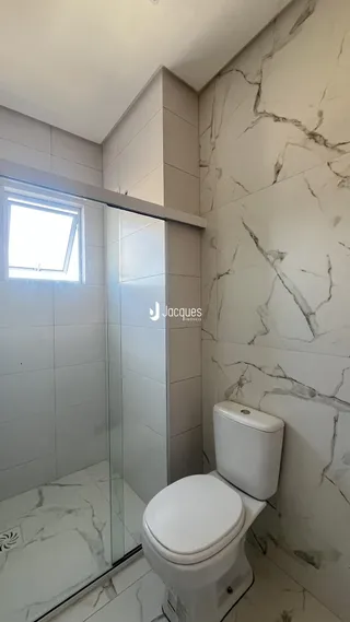 Foto de um banheiro com revestimento em mármore branco.