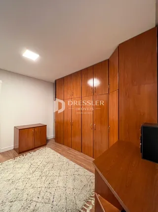Quarto com armários de madeira e tapete no chão.