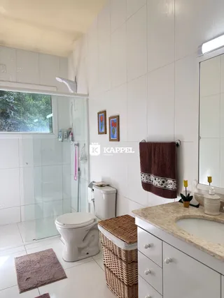 Foto de um banheiro com piso de cerâmica e vaso sanitário branco.