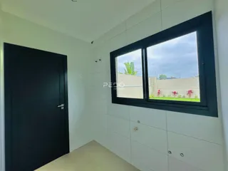 Vista interna de um ambiente com porta e janela em uma residência.