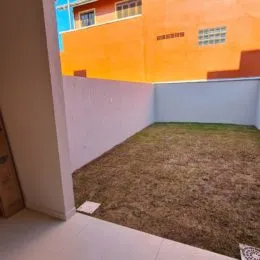 Foto de um espaço interno com piso de grama seca.