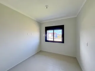 Vista interna de um corredor com paredes brancas e piso claro.