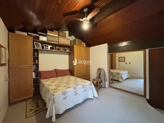 Quarto com armário e cabeceira de madeira no interior da residência.