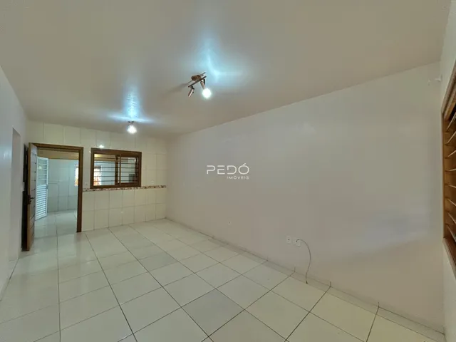 Imagem de um ambiente interno com piso de cerâmica e paredes brancas.