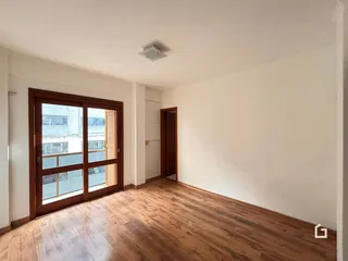 Ambiente interno com piso de madeira clara e paredes brancas.