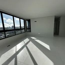 Vista ampla de um ambiente interno com grande janela mostrando a paisagem urbana.
