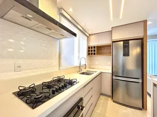 Foto de uma cozinha moderna com armários brancos e bancadas claras.