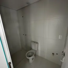 Foto de um banheiro interno com revestimento branco.