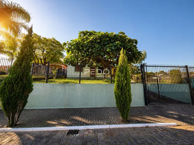 Vista externa de uma propriedade com muro e cerca de ferro.