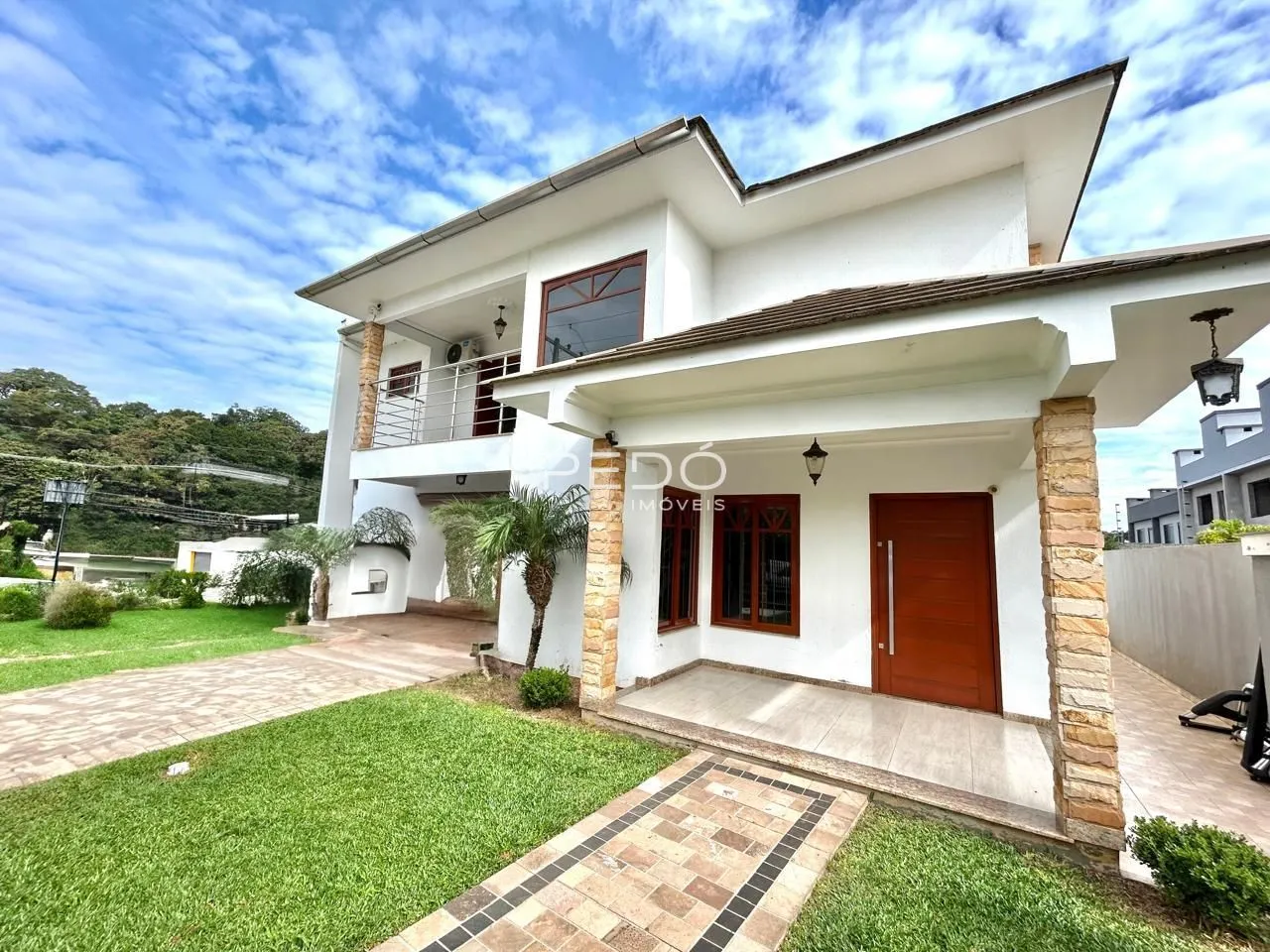 Fachada de uma residência em Lajeado, Brasil, com jardim e pátio frontal.