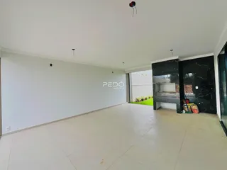 Ambiente interno amplo com piso claro e paredes brancas.
