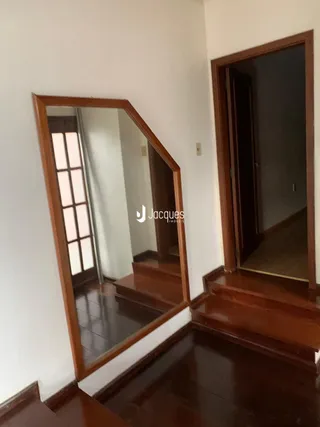 Hall de entrada com piso de madeira e espelhos.