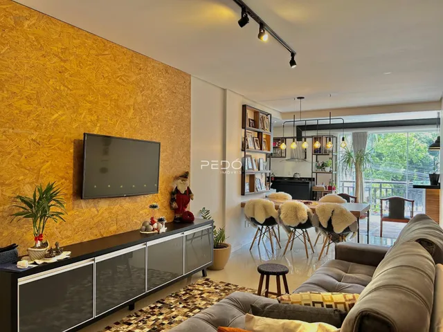 Sala de estar moderna com parede de textura amarela e grande janela de vidro.
