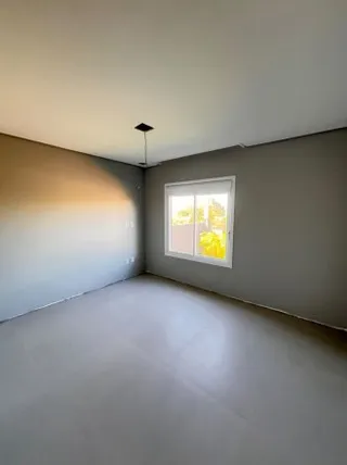 Foto de um cômodo vazio com paredes claras e piso liso.