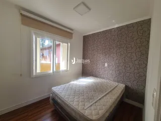Quarto com piso de madeira e parede decorada em Lajeado.