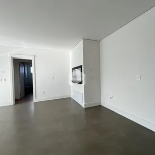 Interior de uma área de circulação com paredes brancas e piso cinza.