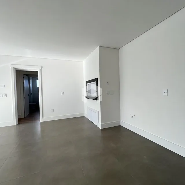 Interior de uma área de circulação com paredes brancas e piso cinza.