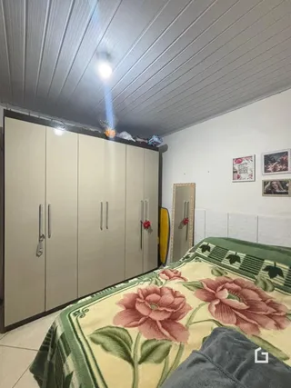 Quarto com armários embutidos e cama decorada.