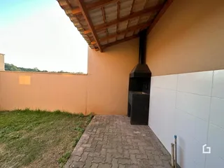 Vista da fachada de uma residência com telhado de madeira e jardim.