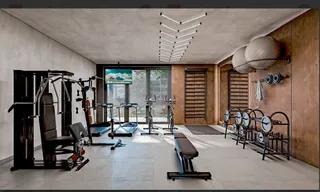 Sala de ginástica com equipamentos de musculação e pesos.