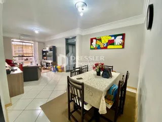 Sala de estar com piso de cerâmica e móveis de madeira clara.