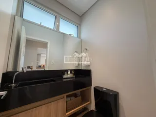 Vista da bancada e espelho de um banheiro em imóvel no Brasil.