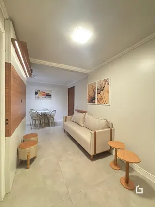 Sala de estar com sofá e detalhes de madeira na parede.