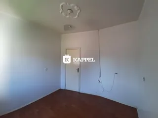Ambiente interno com piso de madeira e porta branca na residência.