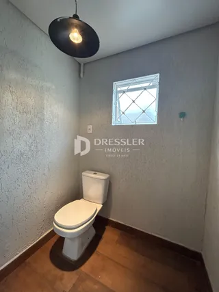Foto de um banheiro interno com vaso sanitário e janela.