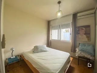 Quarto com cama e janela em uma residência.