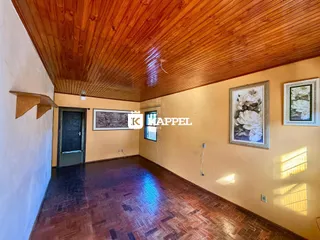 Sala com piso de madeira e teto de tábuas de madeira.