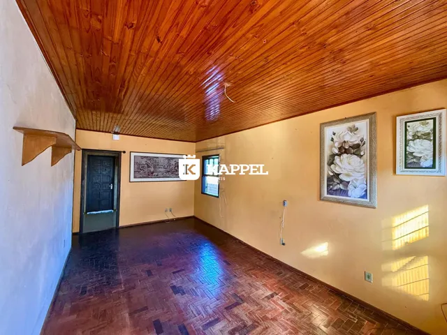 Sala com piso de madeira e teto de tábuas de madeira.