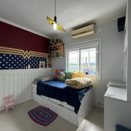 Quarto com cama e cabeceira na parede em um imóvel.
