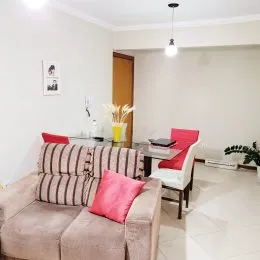 Sala de estar com sofá e paredes brancas.