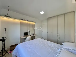 Quarto com armários embutidos e cama grande em um imóvel.