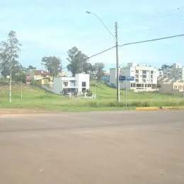 Vista externa de uma rua com gramado e edifícios ao fundo em Lajeado.