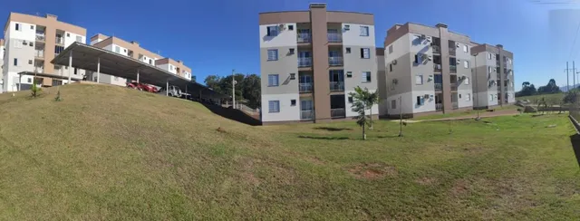 Vista externa de um complexo residencial com área gramada.