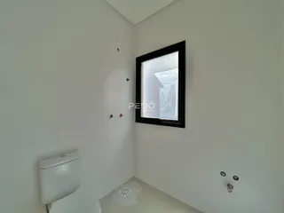 Corredor interno com vaso sanitário e espelho emoldurado.