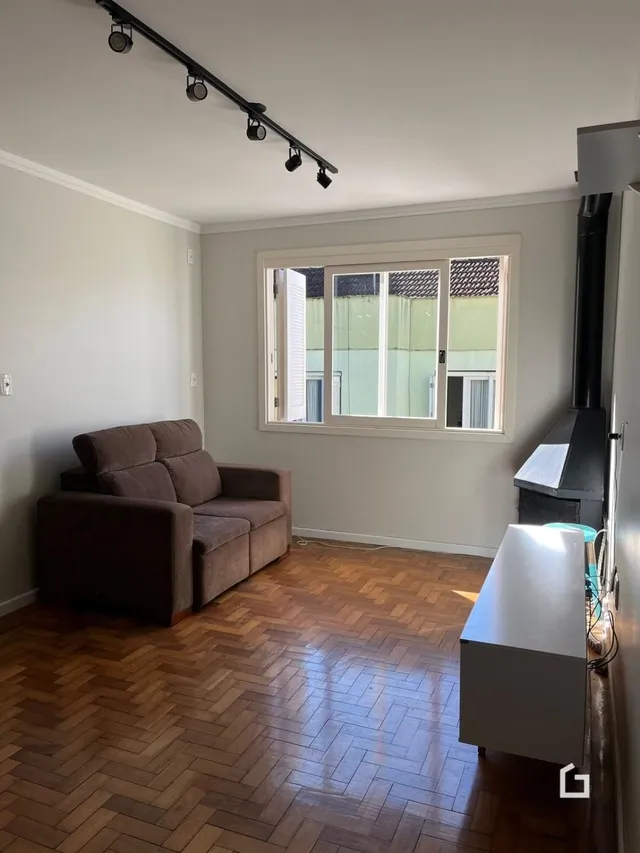Sala de estar com piso de madeira e janela.