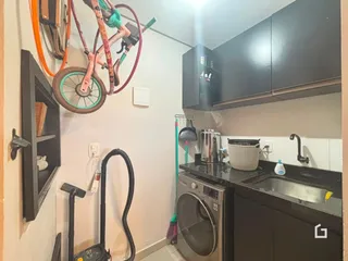 Foto de uma cozinha com armários escuros e máquina de lavar roupa.