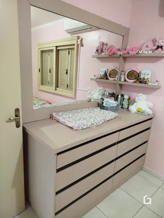 Quarto com espelho e cabeceira de madeira em um imóvel no Brasil.