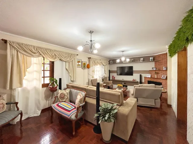 Sala de estar com piso de madeira e lareira em um imóvel no Brasil.