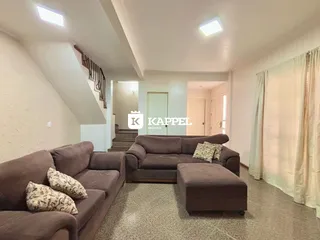 Sala de estar com sofá grande e piso de carpete.