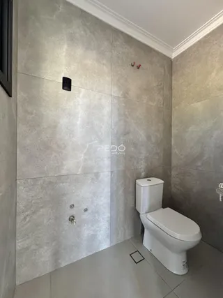 Banheiro com revestimento de grande formato e piso claro.