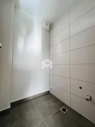 Hall de corredor com paredes brancas e piso escuro.