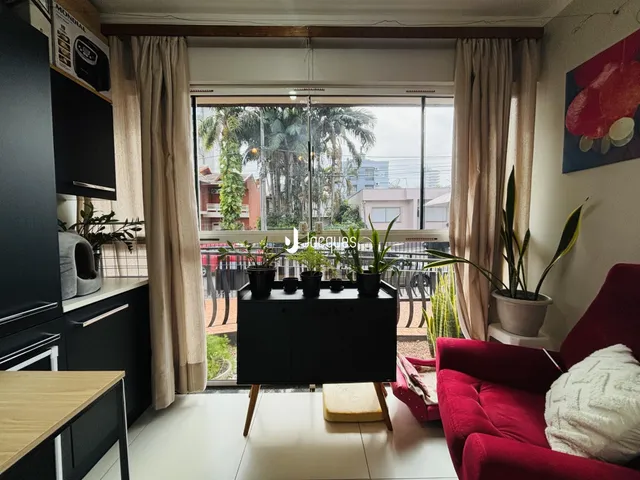 Sala de estar com móveis escuros e vista para o exterior.